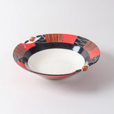 Handmade ceramic serving bowl featuring abstract African-inspired patterns in red, black, brown, and white, finished with decorative wooden beads along the rim