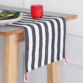 Handwoven black and white striped cotton table runner with tassels styled on a dining table, creating an elegant table setting and dining table décor