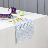 Blue lily hand block printed cotton table runner styled on a dining table with coordinated tableware and home decor accents