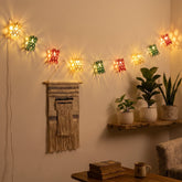 Intricately woven multicoloured bamboo string lights illuminating a bohemian-style indoor reading nook with warm, multicolored ambient patterns.