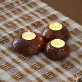 Brass inlay wooden T-light holder set of 3 displayed with lit tea lights, featuring star, scalloped, and lotus designs for festive decor and handmade home accents