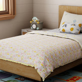 Hand block printed cotton quilt featuring bunny garden motifs in soft multicolour tones, styled on a single bed with a light and airy look