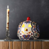 Multi-coloured floral ceramic pumpkin tea light holder styled on a console table creating a festive and decorative home setting