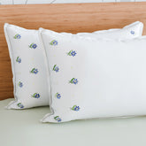 Forget-me-nots embroidered pillow cases styled on a bed adding soft floral elegance to bedroom decor