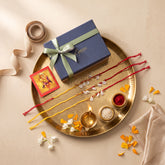 Ghungroo and Sea Shells Handmade Rakhi Set for Brothers, Set of 3, displayed with an aarti thali, diya, and kumkum during Raksha Bandhan rituals.