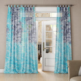 Living room with a grey and blue tie-dye mulmul cotton curtain, and it's a soft, breezy drape.