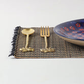 Handmade Madhurkathi table mats styled on a dining table with cutlery and ceramic plates, creating an elegant natural table setting