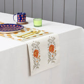 Marigold buta block printed Chanderi table runner styled on a dining table with coordinated tableware and festive decor accents