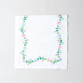 Folded white cotton table runner showcasing colourful floral vine embroidery and handcrafted Bengal chikankari detailing