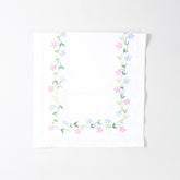 Folded white cotton table runner showcasing colourful daisy embroidery and handcrafted Bengal chikankari detailing