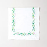 Folded Bengal chikankari runner showcasing multicoloured floral embroidery on soft white cotton table linen