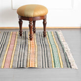 Multicolor geometric stripe block printed cotton dhurrie rug styled in a living room, adding vibrant handcrafted character to home interiors