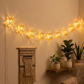 Eco-friendly handwoven natural bamboo cylinder string lights styled across a minimalist-style living room wall as home decor.