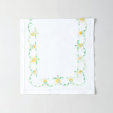 Folded white cotton table runner showcasing orange and green floral embroidery and handcrafted Bengal chikankari detailing