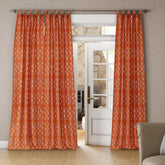Bright living room with orange-rust tab top cotton curtains framing white French doors and allowing soft natural light
