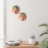 Handcrafted peach Cheriyal couple mask set displayed as wall decor, showcasing traditional Telangana folk art and hand-painted papier-mache craftsmanship