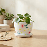 Pink blossom ceramic planter with tray styled for compact indoor plant decor on tabletops and shelves.