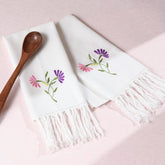 Pink and purple floral embroidered cotton kitchen towels styled with kitchen accessories for elegant kitchen linen decor