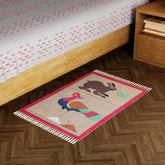 Pink handwoven cotton dhurrie with rabbit and peacock motifs styled in a cosy living space as a decorative floor accent