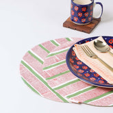 Set of two round cotton placemats with red and green stripe block print patterns styled on a dining table, creating a colourful table setting and dining table décor