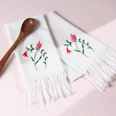 Red penstemon embroidered cotton kitchen towels styled with a wooden spoon for elegant kitchen linen decor