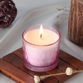 Rose scented soy wax candle glowing in a chiseled glass holder