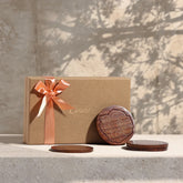 Rosewood coaster gift set with marigold floral brass inlay, beautifully styled as a festive gift with elegant packaging