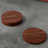 Rosewood coaster set with tiger brass inlay, styled on a table top, making an elegant corporate gift