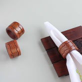 Round wooden napkin rings with lotus brass inlay styled on a dining table for elegant table setting decor