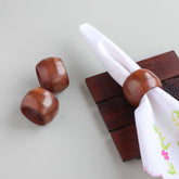 Round wooden napkin rings with brass inlay styled on a dining table for an elegant table setting decor