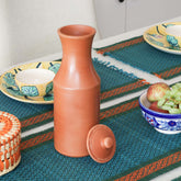 terracotta-water-pitcher-1100ml-styled-dining.jpg
Alt Text: Handmade terracotta water pitcher with lid styled on a dining table alongside floral plates, and a fruit bowl