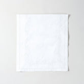 Folded white cotton table runner showcasing delicate white daisy embroidery and handcrafted Bengal chikankari detailing