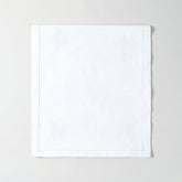 Folded white cotton table runner showcasing delicate chikankari wild floral embroidery and premium handmade craftsmanship
