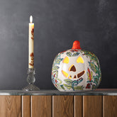 Yellow floral ceramic pumpkin tea light holder styled with candlelight in a festive home decor setting