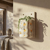 Wall-mounted ceramic flower pot styled with indoor greenery, adding a fresh and decorative touch to a modern room wall decor setup.