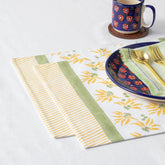 Yellow lily block printed cotton placemats styled on a dining table with plates and cutlery for an elegant table setting