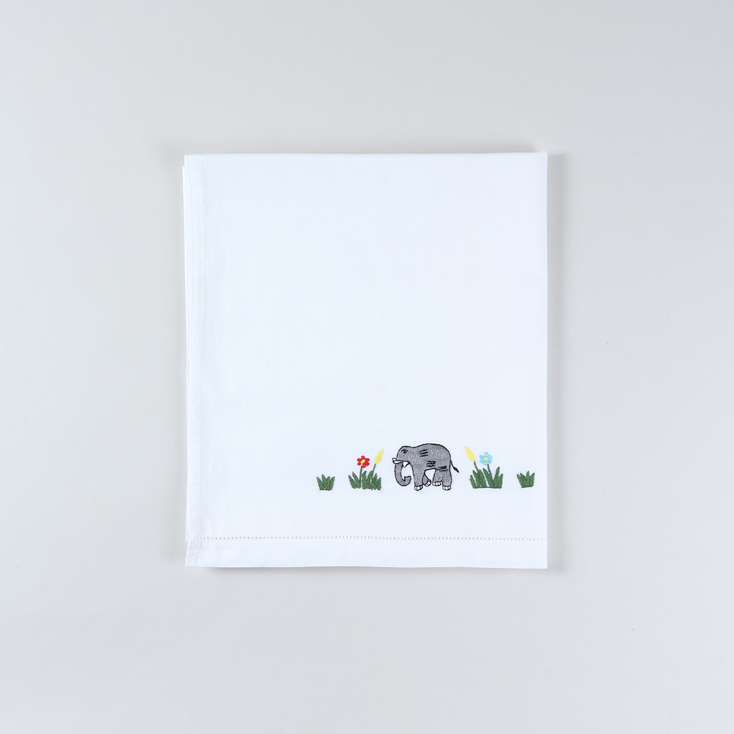 Folded cotton kids bedsheet and pillow cover set featuring colourful elephant hand embroidery on a white cotton base
