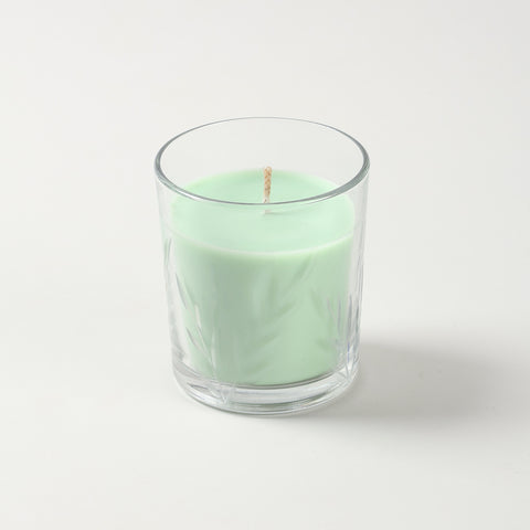 Green apple scented soy candle in decorative green glass jar