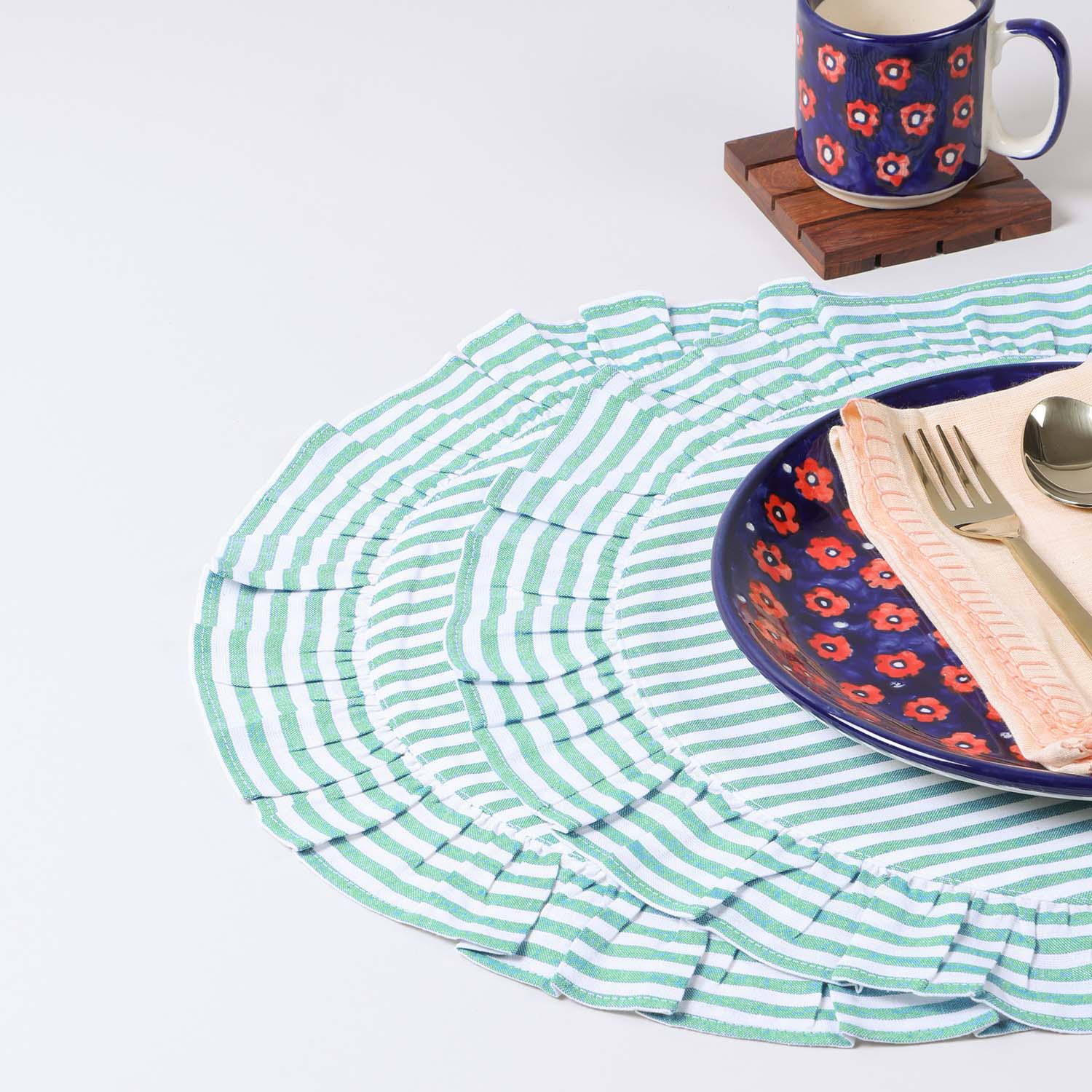 Set of two round cotton placemats with green stripe patterns and frilled edges styled on a dining table, creating a fresh and elegant table setting