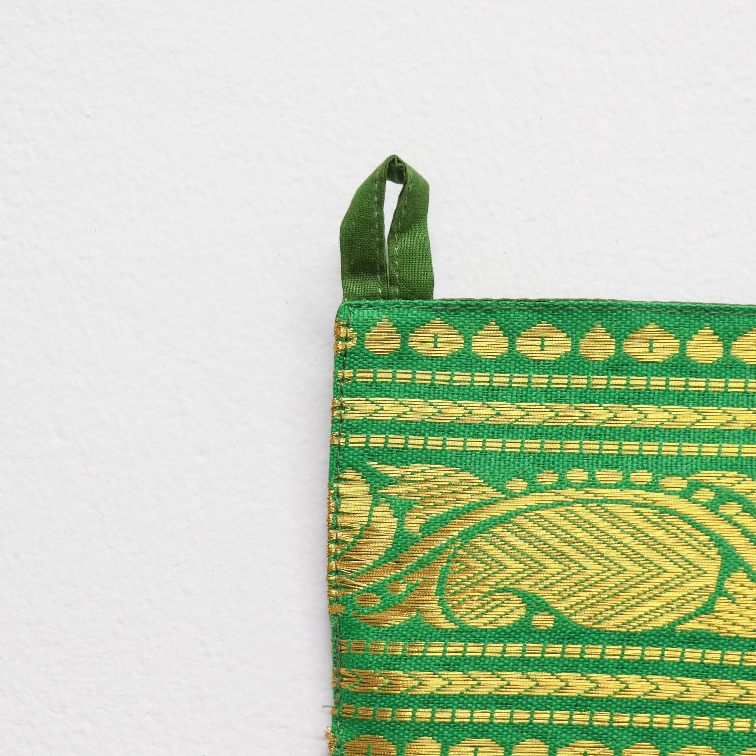  Handcrafted green fabric toran featuring intricate gold zari threadwork and auspicious paisley motifs. Perfect for Diwali, Pooja, and housewarmings.