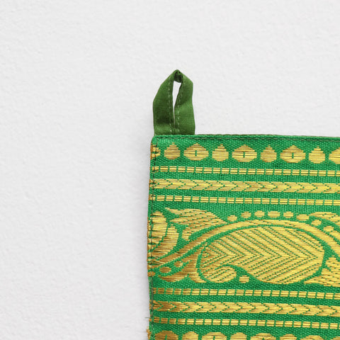  Handcrafted green fabric toran featuring intricate gold zari threadwork and auspicious paisley motifs. Perfect for Diwali, Pooja, and housewarmings.