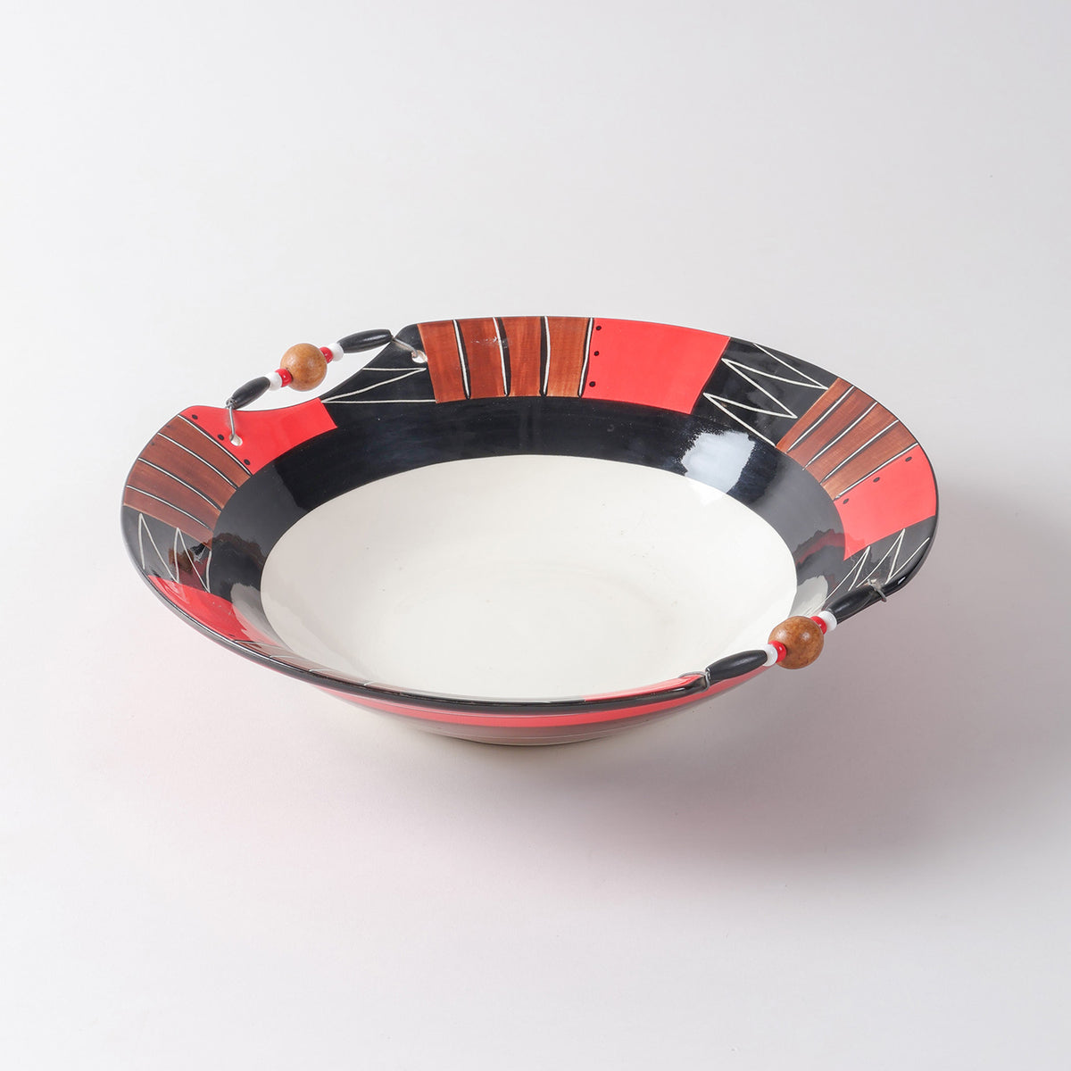 Handmade ceramic serving bowl featuring abstract African-inspired patterns in red, black, brown, and white, finished with decorative wooden beads along the rim