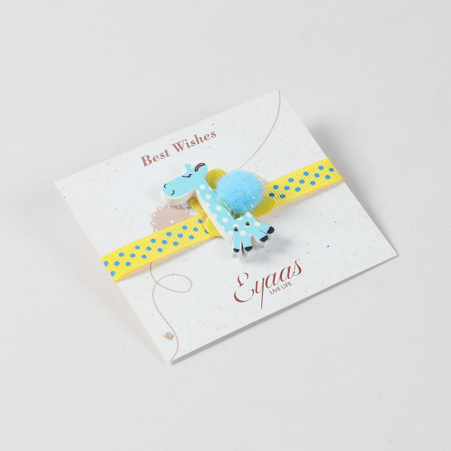 Angled view of the handmade sky blue giraffe Wooden Kids Rakhi attached to an Best Wishes greeting card.