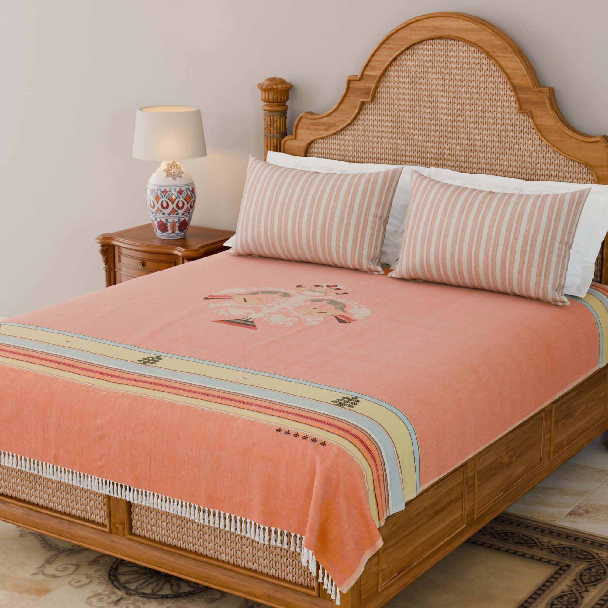 Handwoven Bawan Buti cotton bedcover in orange styled on a wooden bed with tassel details in a contemporary bedroom setting