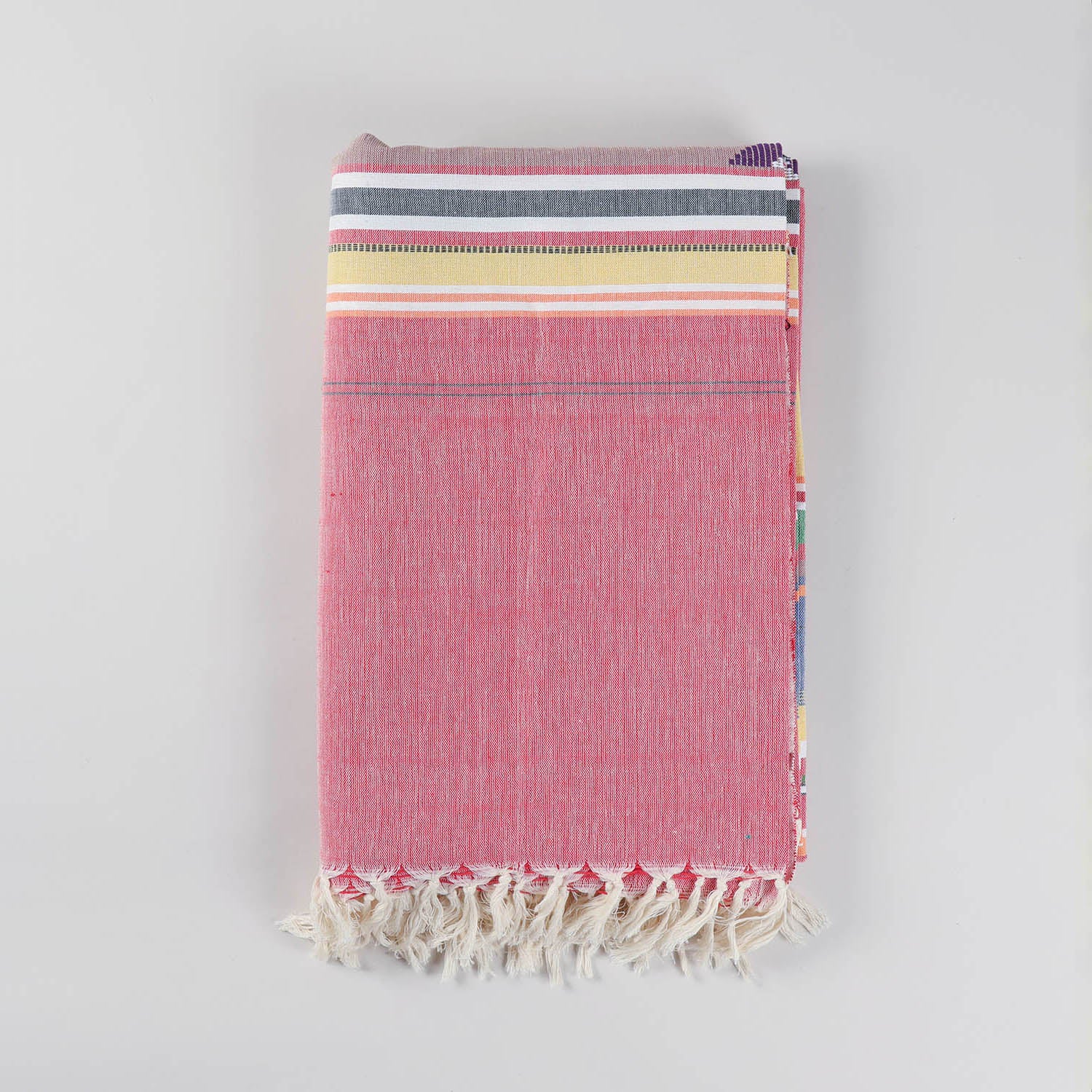 Folded handloom cotton bedcover in red showcasing colourful woven stripes and handcrafted white fringe tassels