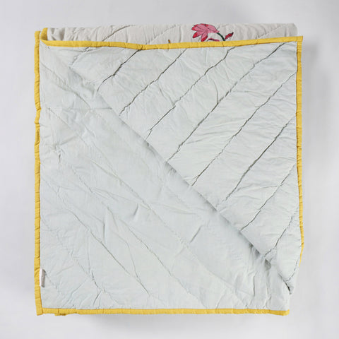 Reversible cotton quilted bedspread displaying both front and back designs with traditional block printed floral motifs