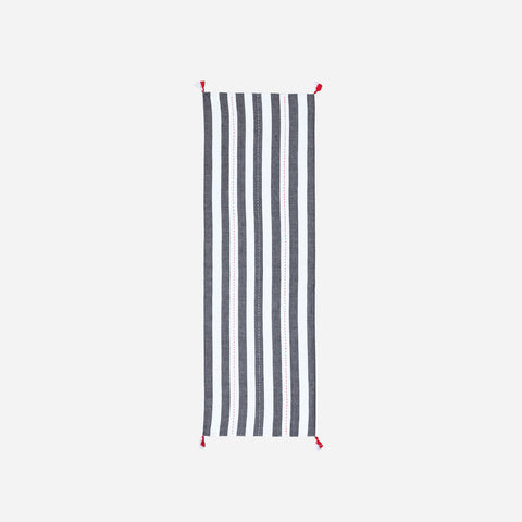 Full-length handwoven cotton table runner featuring black and white stripe patterns with tassels displayed on a plain background