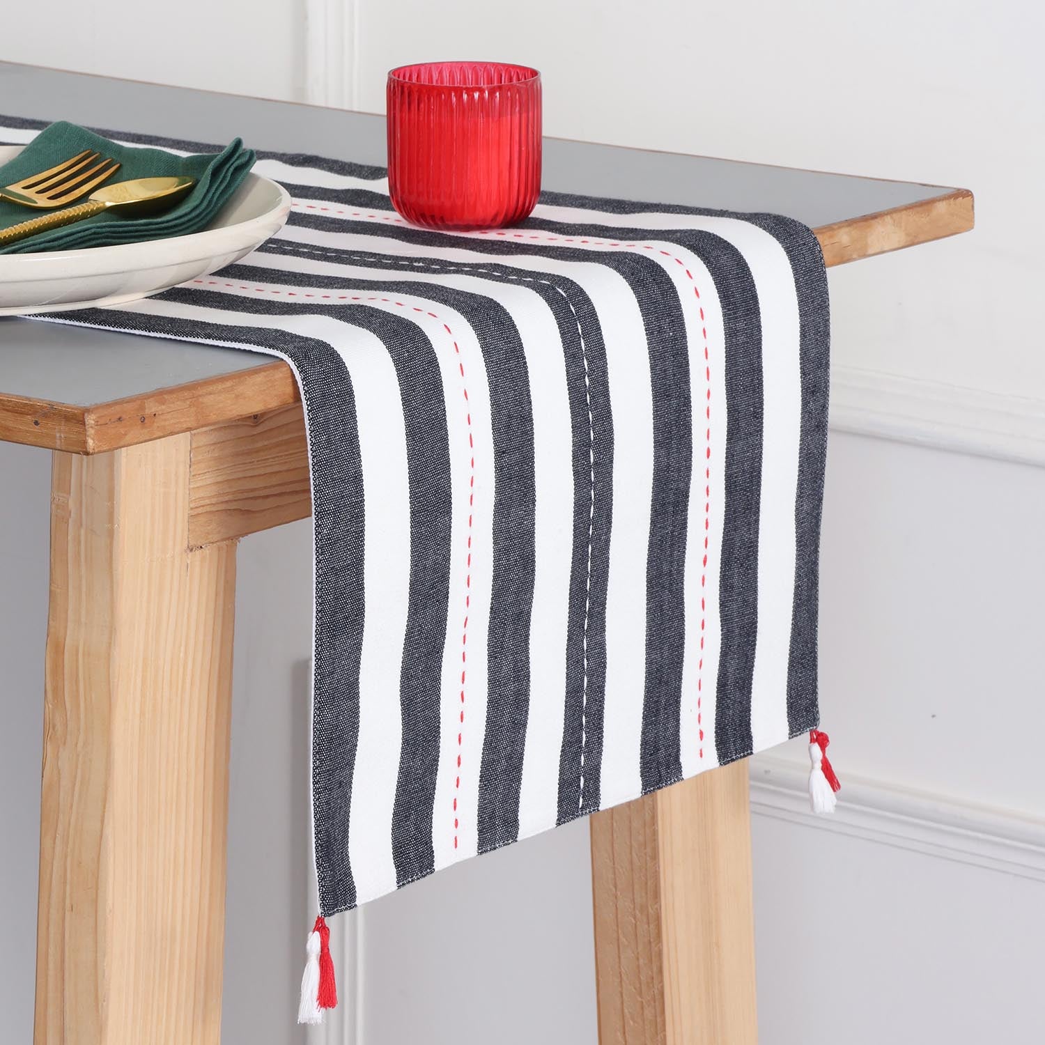Handwoven black and white striped cotton table runner with tassels styled on a dining table, creating an elegant table setting and dining table décor