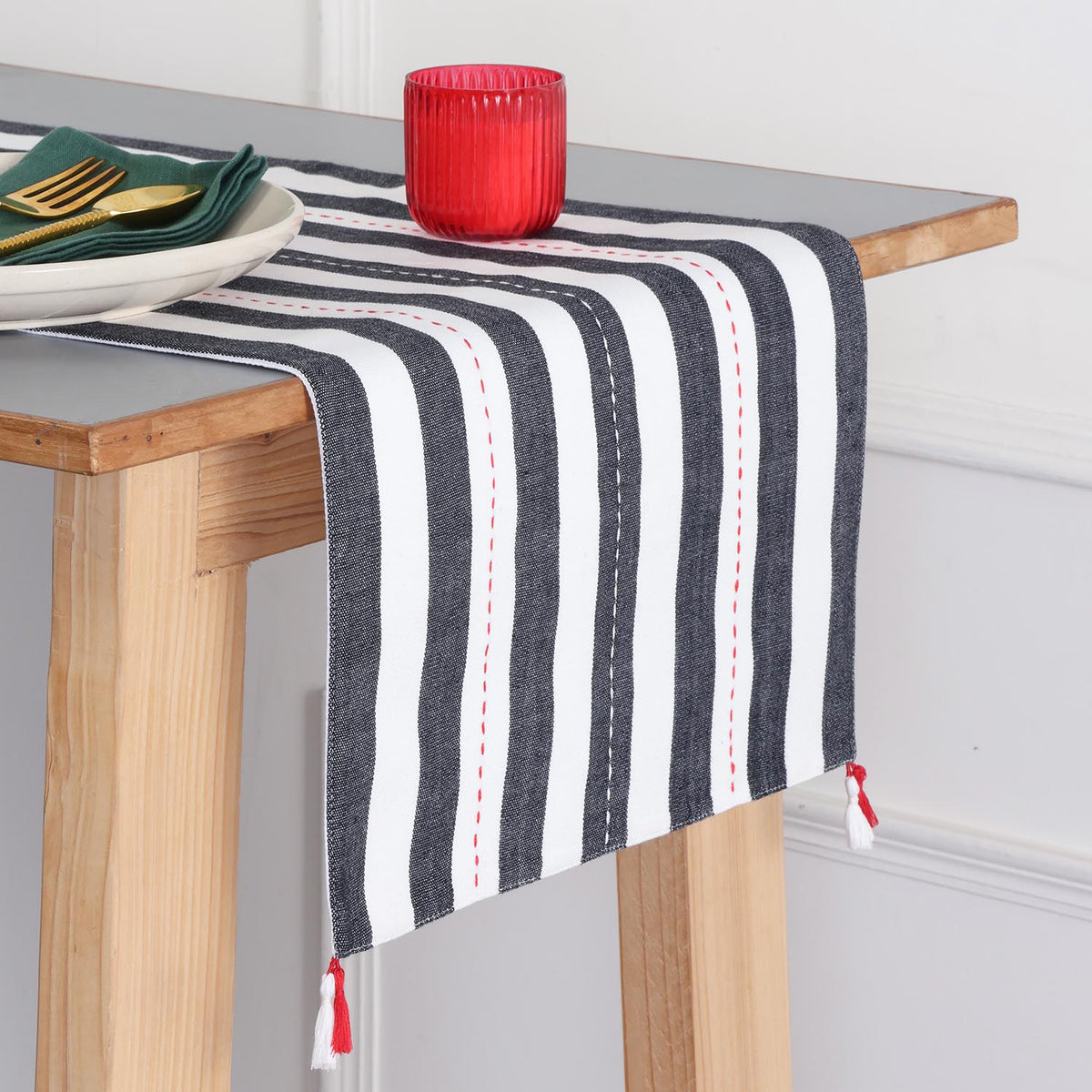 Handwoven black and white striped cotton table runner with tassels styled on a dining table, creating an elegant table setting and dining table décor