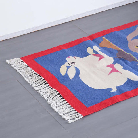 Angled view of a cotton dhurrie featuring folk-inspired animal motifs and vibrant woven patterns